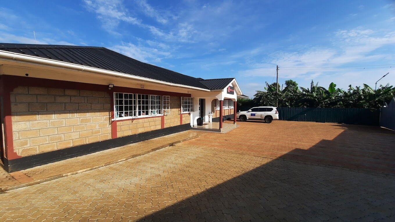 A building with a brick facade, a tiled roof, and a paved driveway.