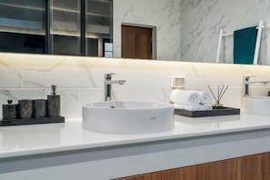 A bathroom with a white marble countertop, a round sink, and a mirror above it. - Two Flamingo Villa 1 (Phuket)