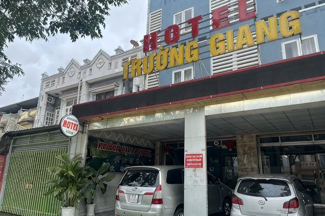 Un hotel con un letrero que dice 'HOTEL TRUONG GIANG' y una dirección web parcialmente visible.