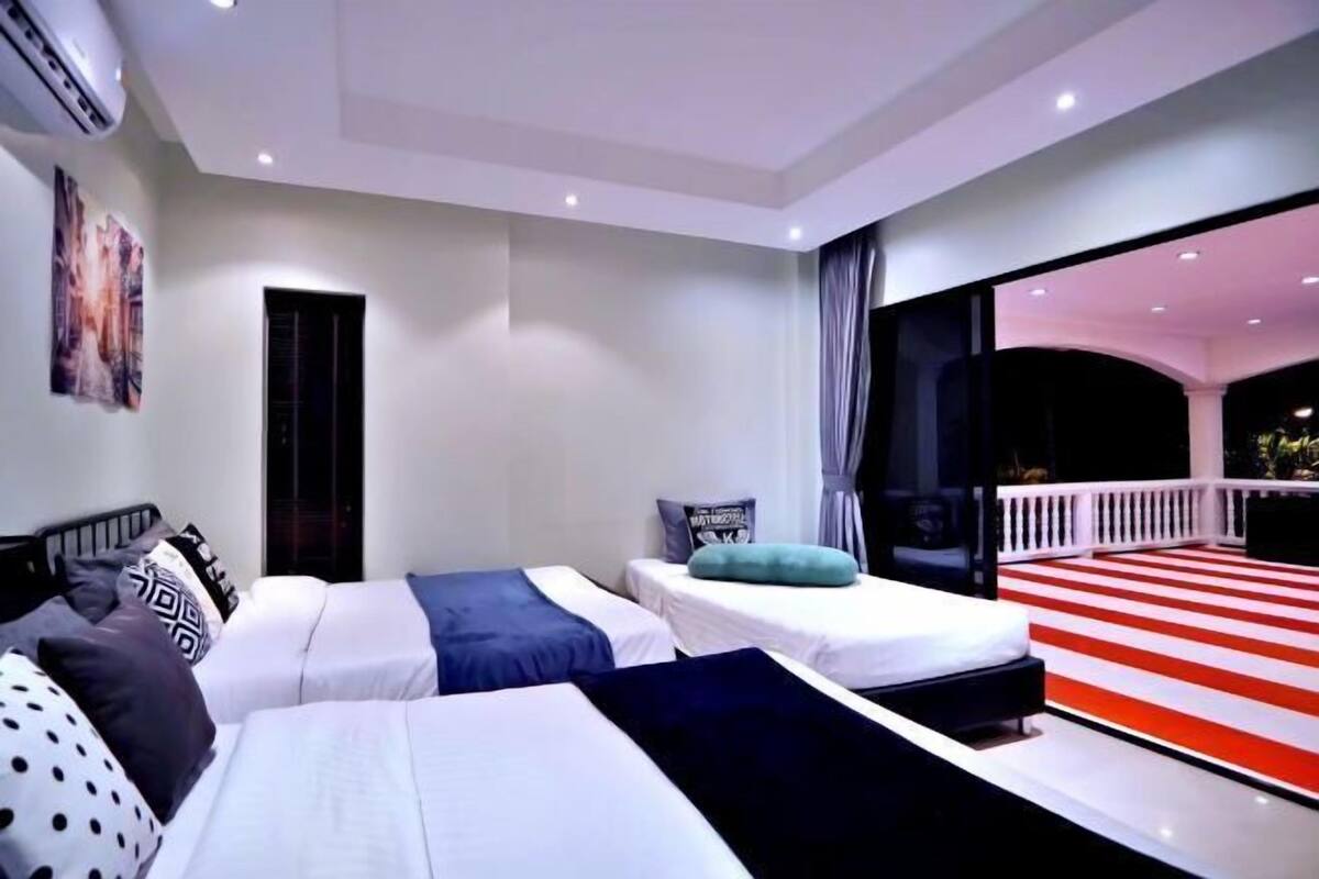 A hotel room with two beds, a large window, and a balcony.