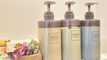 Three toiletry bottles with pumps on a surface.