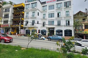 A multi-story building with a sign for 'SAPA COSTY HOTEL' on the top floor. - Sapa Cosy Hotel (TT. Sa Pa)