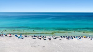 A beach with white sand, clear turquoise water, and several umbrellas. - *Majestic Sun A801*Updated*Heated Pools +Hot Tubs*Gym*Pickleball & Tennis* (Miramar Beach)