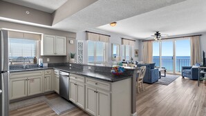 A modern kitchen with a central island, large windows, and a view of the ocean. - *Majestic Sun A801*Updated*Heated Pools +Hot Tubs*Gym*Pickleball & Tennis* (Miramar Beach)