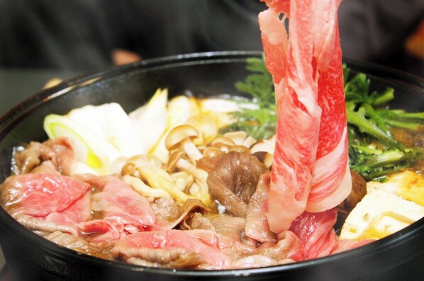 Una olla caliente con diferentes carnes y verduras.