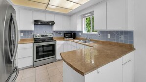 A modern kitchen with white cabinets, a stainless steel refrigerator, a built-in oven, a microwave, and a granite countertop. - Private room in home Richmond, Canada
2 guests 1 bedrooms 1 in-suite bathrooms (Richmond)