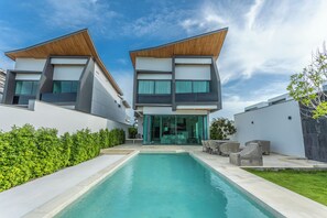 A modern two-story house with a swimming pool in the center, surrounded by a well-maintained lawn and a hedge. - 3BR Villa Hill Views Saltwater Pool V133 (Rawai)