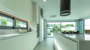 A modern kitchen with white cabinets, a stainless steel sink, and a large island.