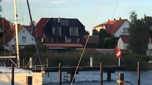 A marina with boats docked, a bridge, and residential buildings in the background. - Holiday Home 'Boddenperle' with Sea View, Private Terrace and Wi-Fi (Breege)