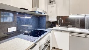 A modern kitchen with a built-in stove, a dishwasher, and a sink. - Starwars Disney 10 minutes by car. Cuisine équipée et Wi-Fi performant (Bussy-Saint-Georges)