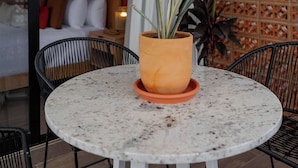 A round table with a potted plant in the center, surrounded by black chairs. - Steps from the Beach at Raíces Nómadas Studio (Puerto Vallarta)