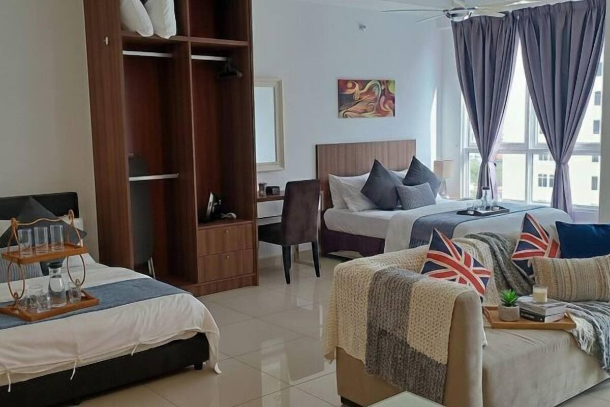 A hotel room with two beds, a wardrobe, a desk, and a chair.