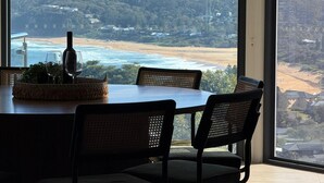 A dining area with a view of a beach and hills.