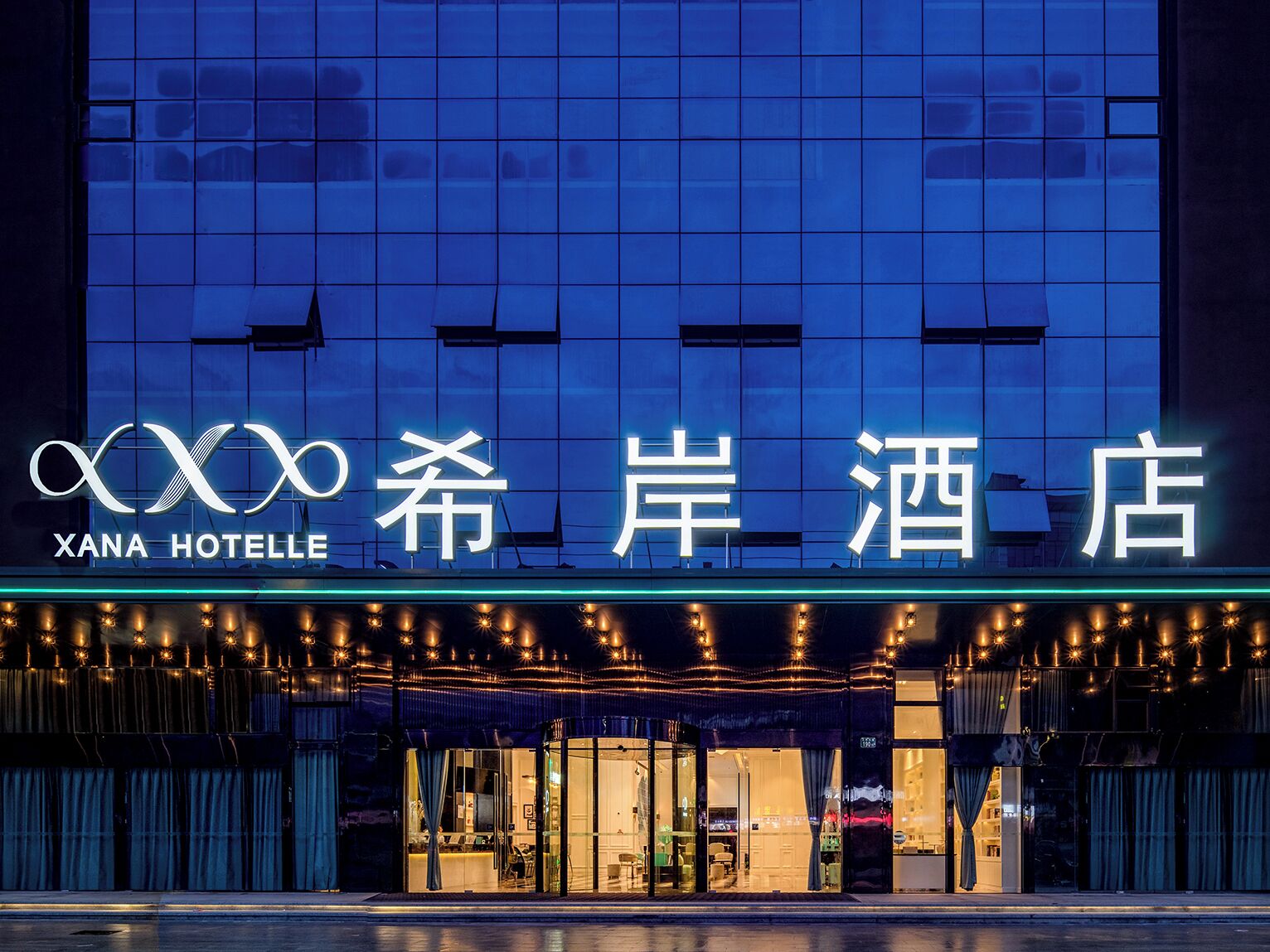 A hotel with a modern facade, illuminated signage, and a well-lit entrance.