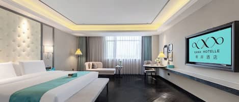 A hotel room with a large bed, a sofa, a desk, and a TV mounted on the wall.