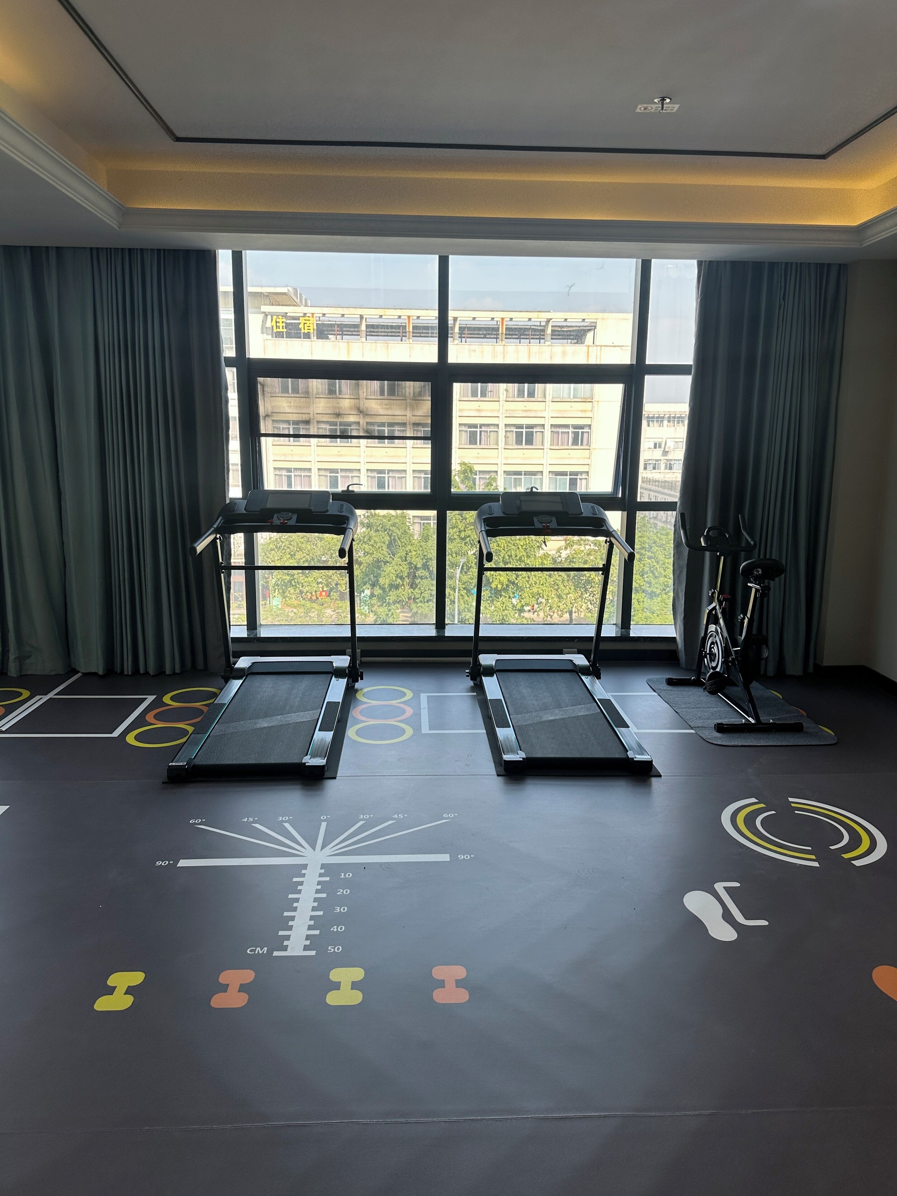 Una palestra con tapis roulant e un'ampia finestra.