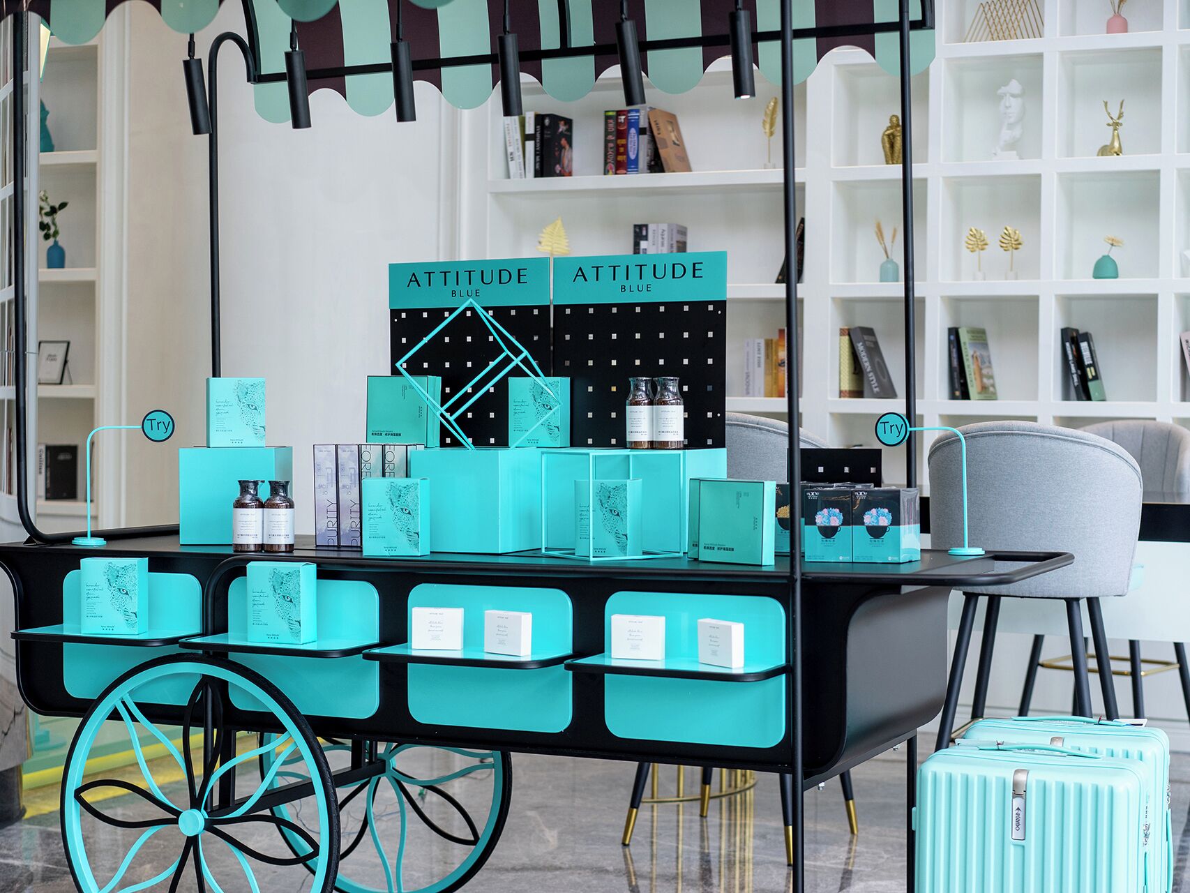 A display cart with various products, a cart with wheels, and a chair in the background.