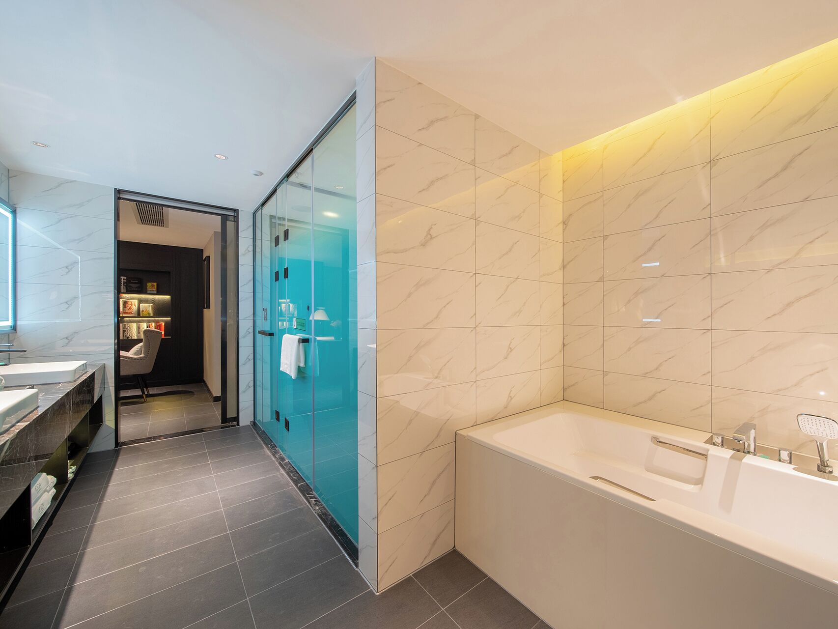 A modern bathroom with a glass shower enclosure, a large bathtub, and a vanity with a mirror.