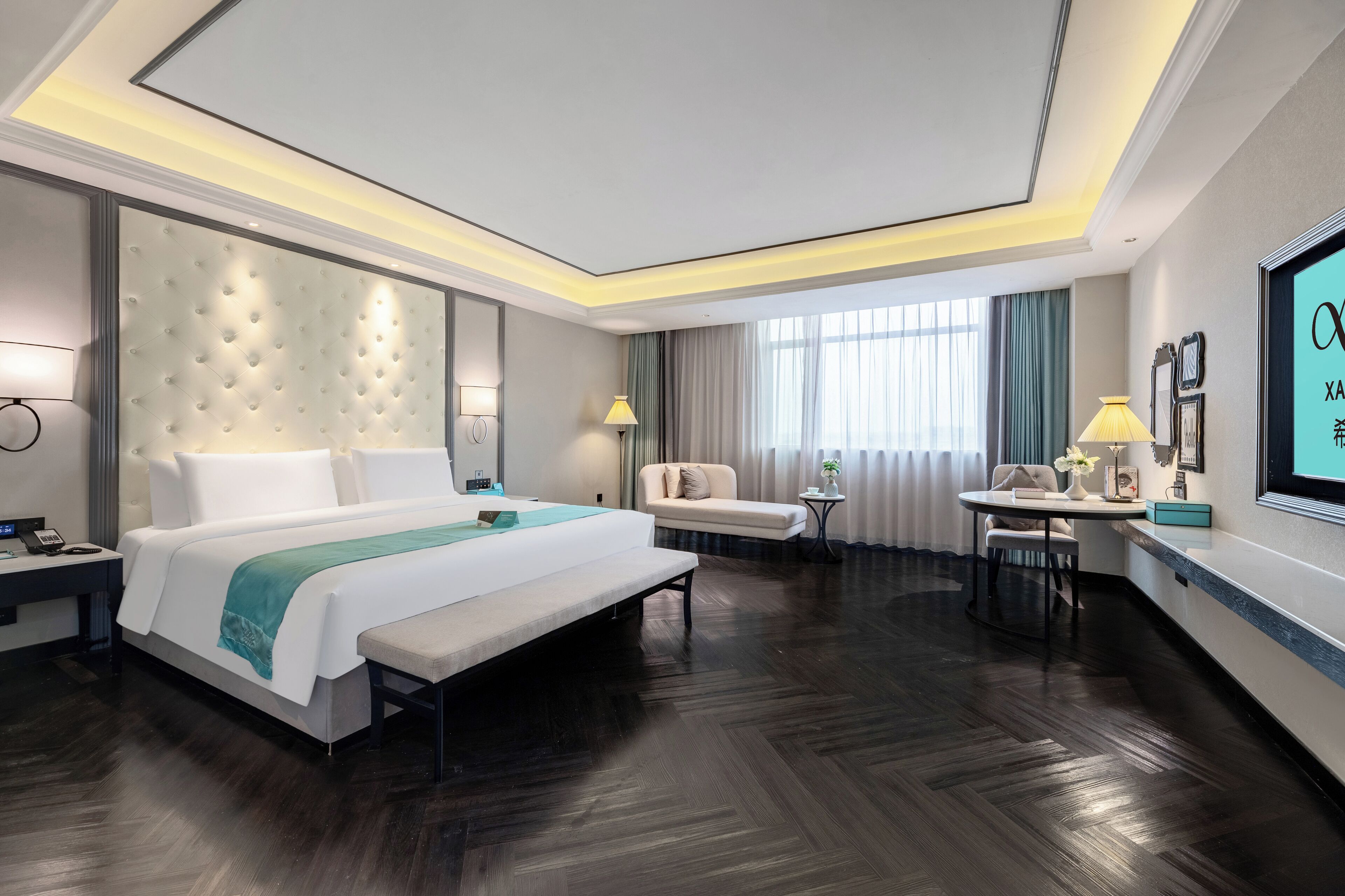 A modern hotel room with a large bed, bedside tables, a desk, and a view of the outdoors.