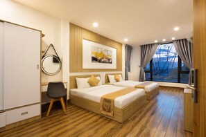 Ein modernes Hotelzimmer mit zwei Betten, einem Schreibtisch, einem Sessel, einem Fernseher und einem großen Fenster mit Blick.