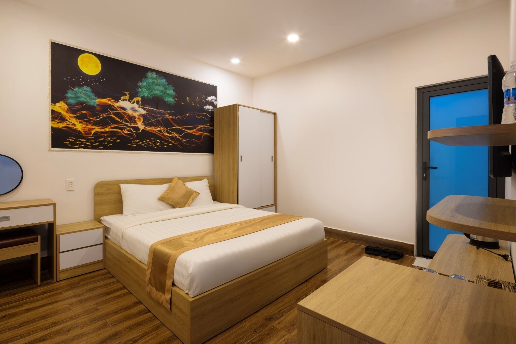 A neatly arranged hotel room with a bed, bedside table, and a painting on the wall.