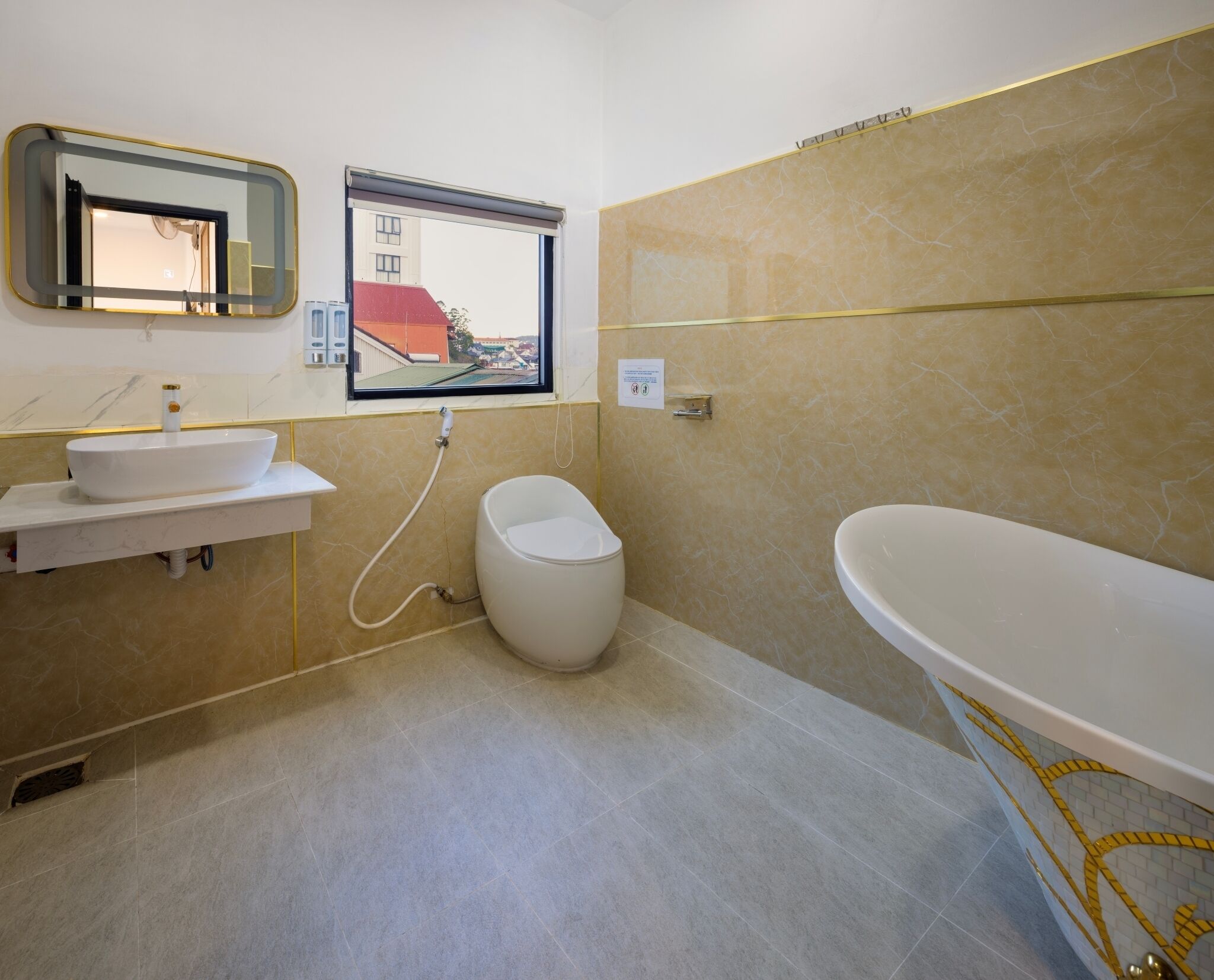 A modern bathroom with a white sink, a toilet, and a freestanding bathtub.