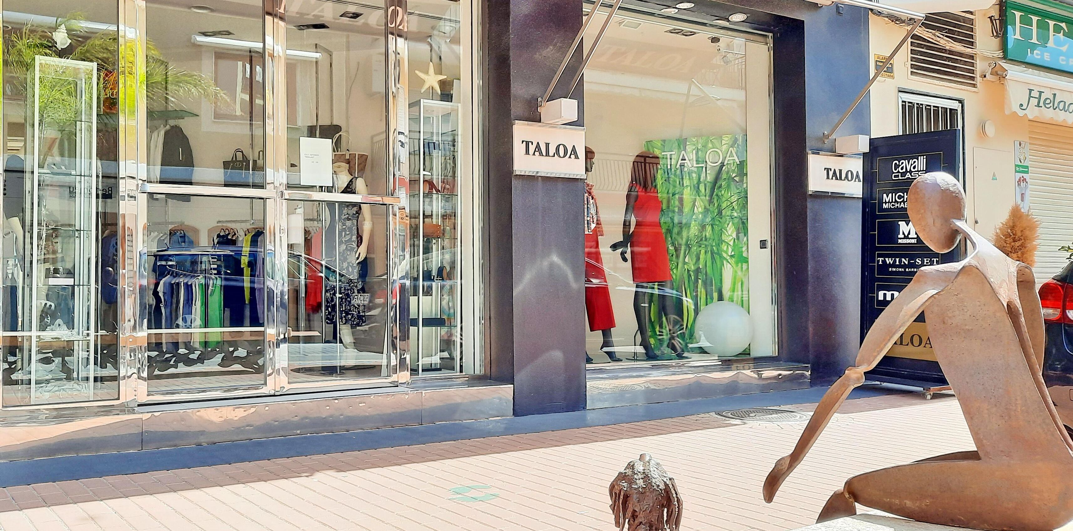 Une vitrine avec des fenêtres en verre où sont exposés des vêtements et des accessoires.