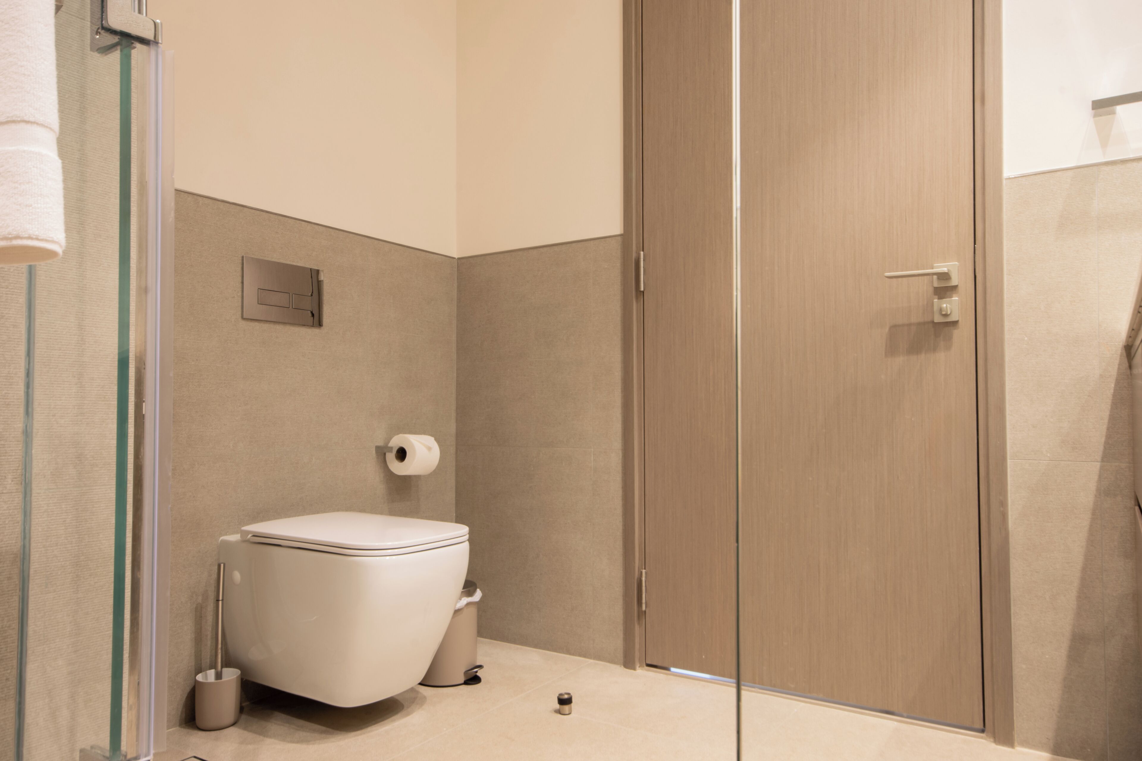 Une salle de bain moderne équipée de toilettes, d’un bidet et d’une douche à parois de verre.