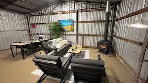 Een rustiek interieur met een eethoek, een bank en een open haard.