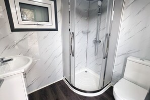 Een douche, handdoeken, zeep, toiletpapier