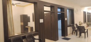 A room with a dining area, a large mirror, and a view of the outside. - Mridul Homestay Orchha  (Orchha)