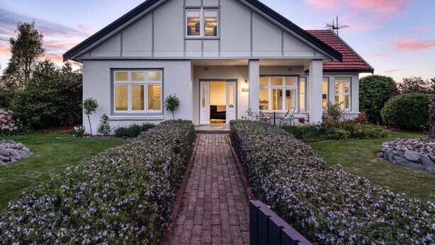 A two-story house with a symmetrical facade, a central entrance, and a brick pathway leading to the door. - Talina - History in the Heart of St Helens (Break O'Day)