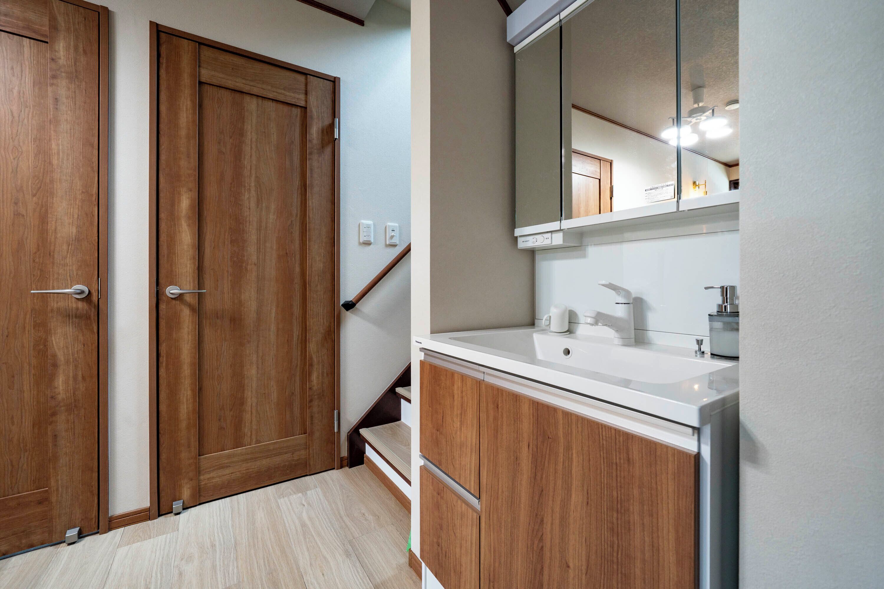 A bathroom with wooden cabinets, a white sink, and a mirror above the sink.