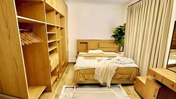 A bedroom with a bed, wooden wardrobe, and a ceiling light fixture.
