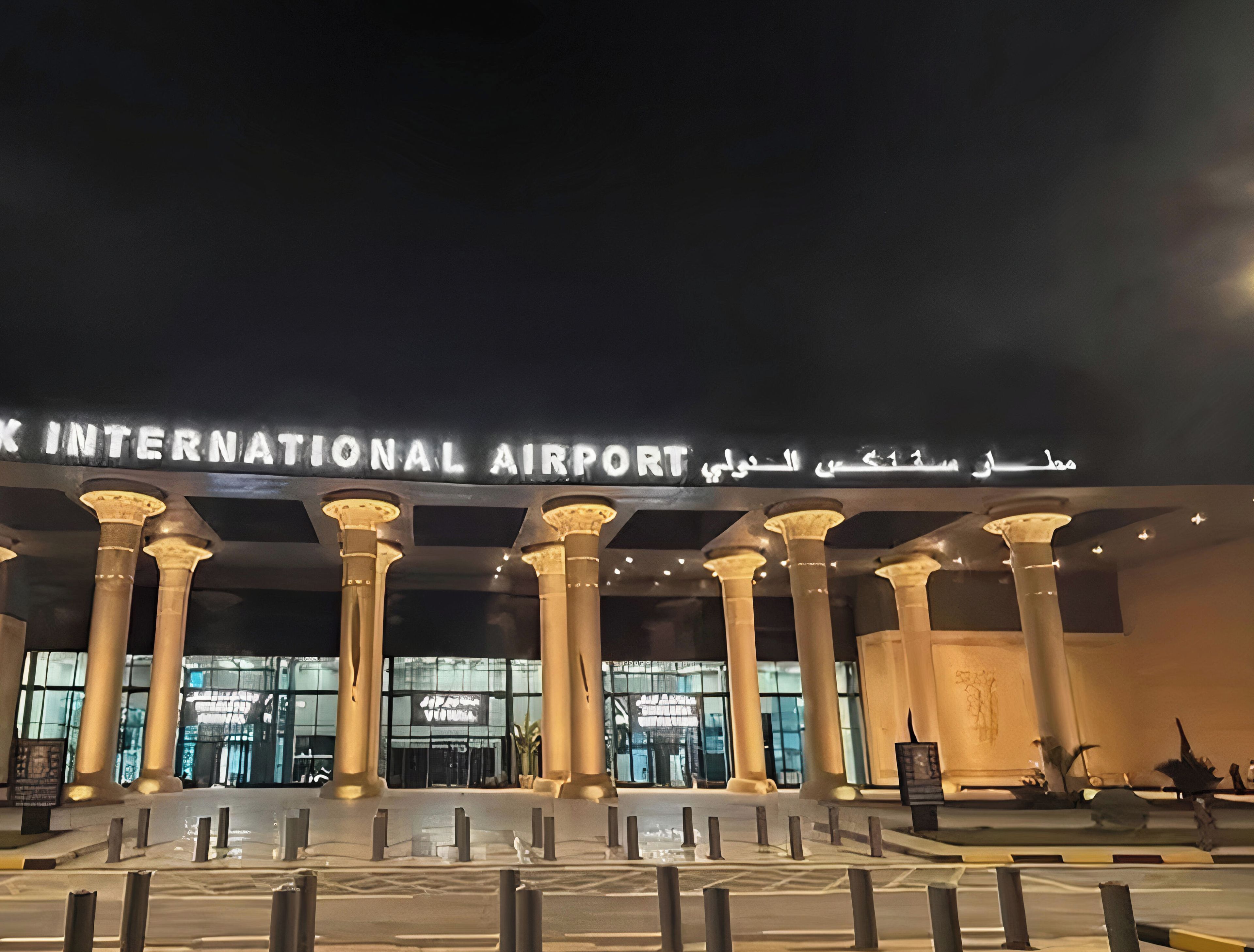 The entrance to Sphinx International Airport with illuminated signage and classical columns.