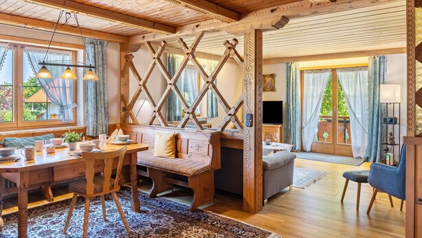 Ein Holzinterieur mit Essbereich, Bank und Fernseher.