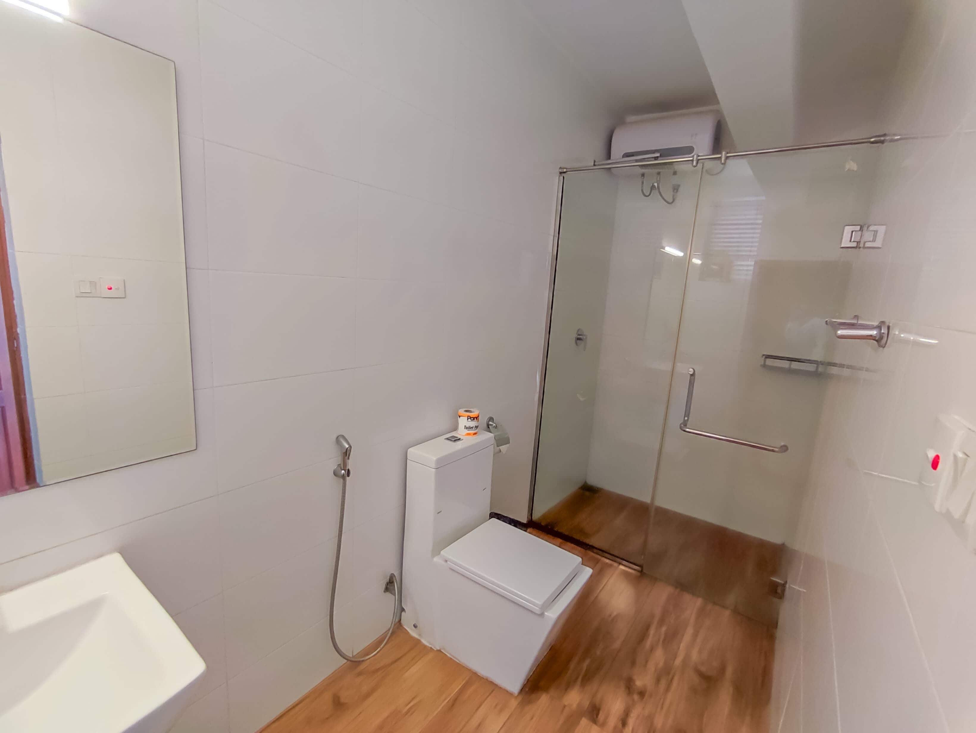 Une salle de bain moderne avec une douche à parois de verre, des toilettes et un lavabo.