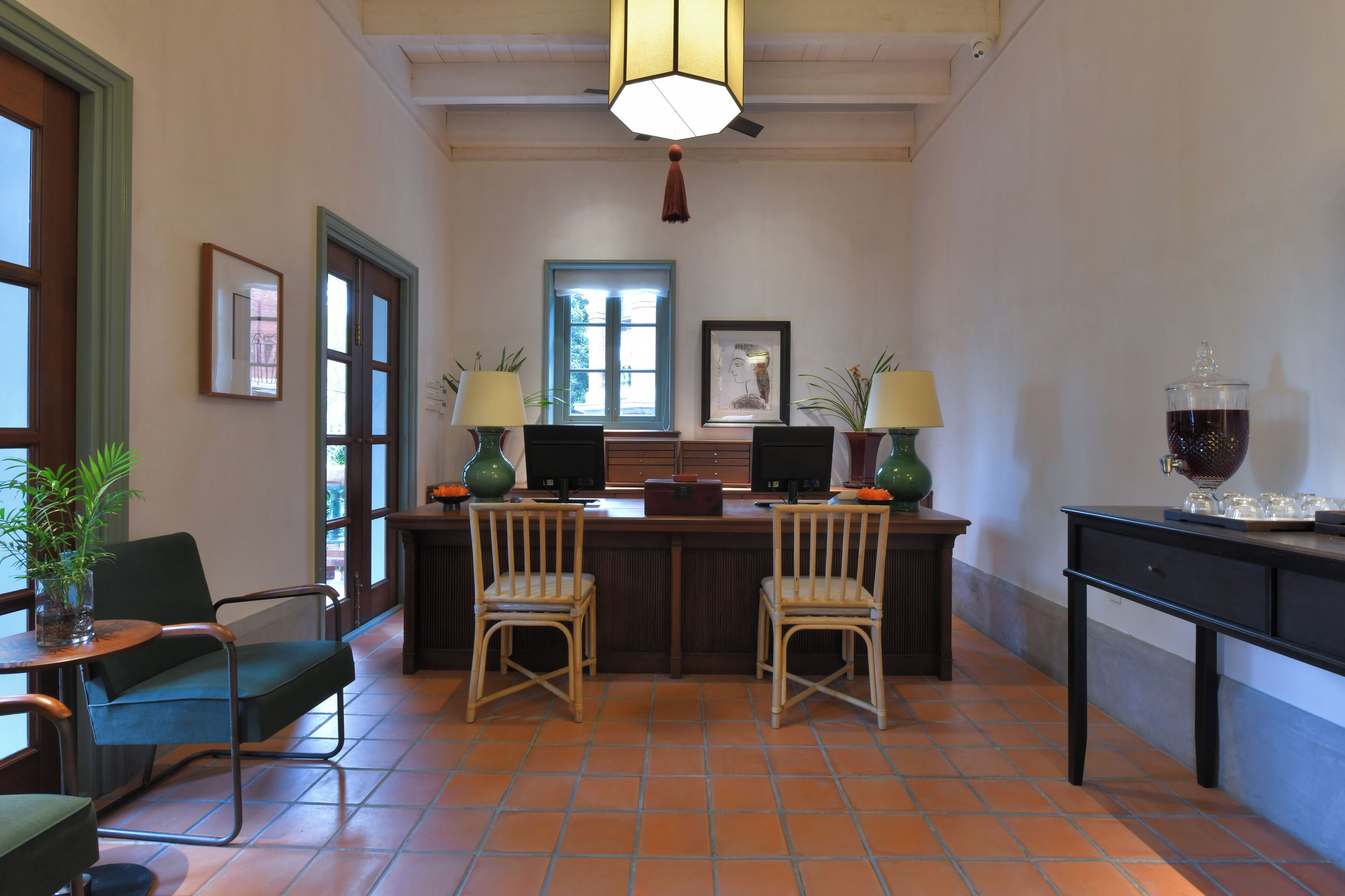 A reception area with two chairs, a desk, a computer, and a coffee station.