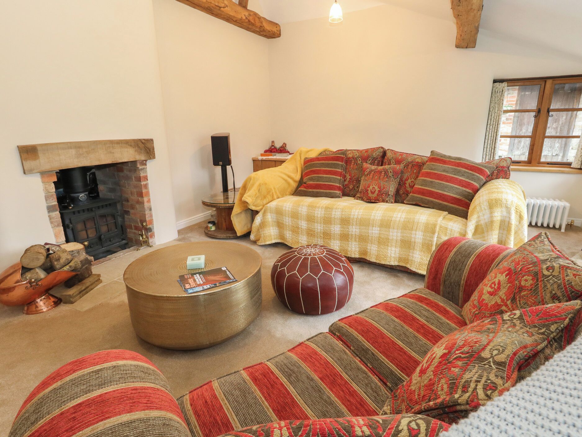 Una sala de estar acogedora con chimenea, un conjunto de sofás, una mesa de centro y un radiador.