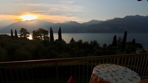 A balcony with a view of a lake and mountains at sunset. - Quiet cozy apartment overlooking the lake, closed parking lot and pool, (Malcesine)