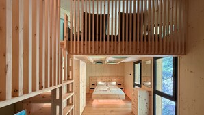 Un intérieur en bois avec un lit superposé, un bureau et une grande fenêtre.