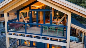 Een houten hut met een serre en een terras.