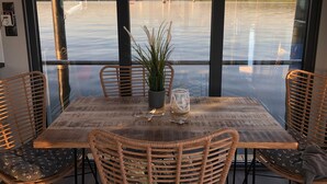 Un comedor con una mesa, sillas y vista al agua.