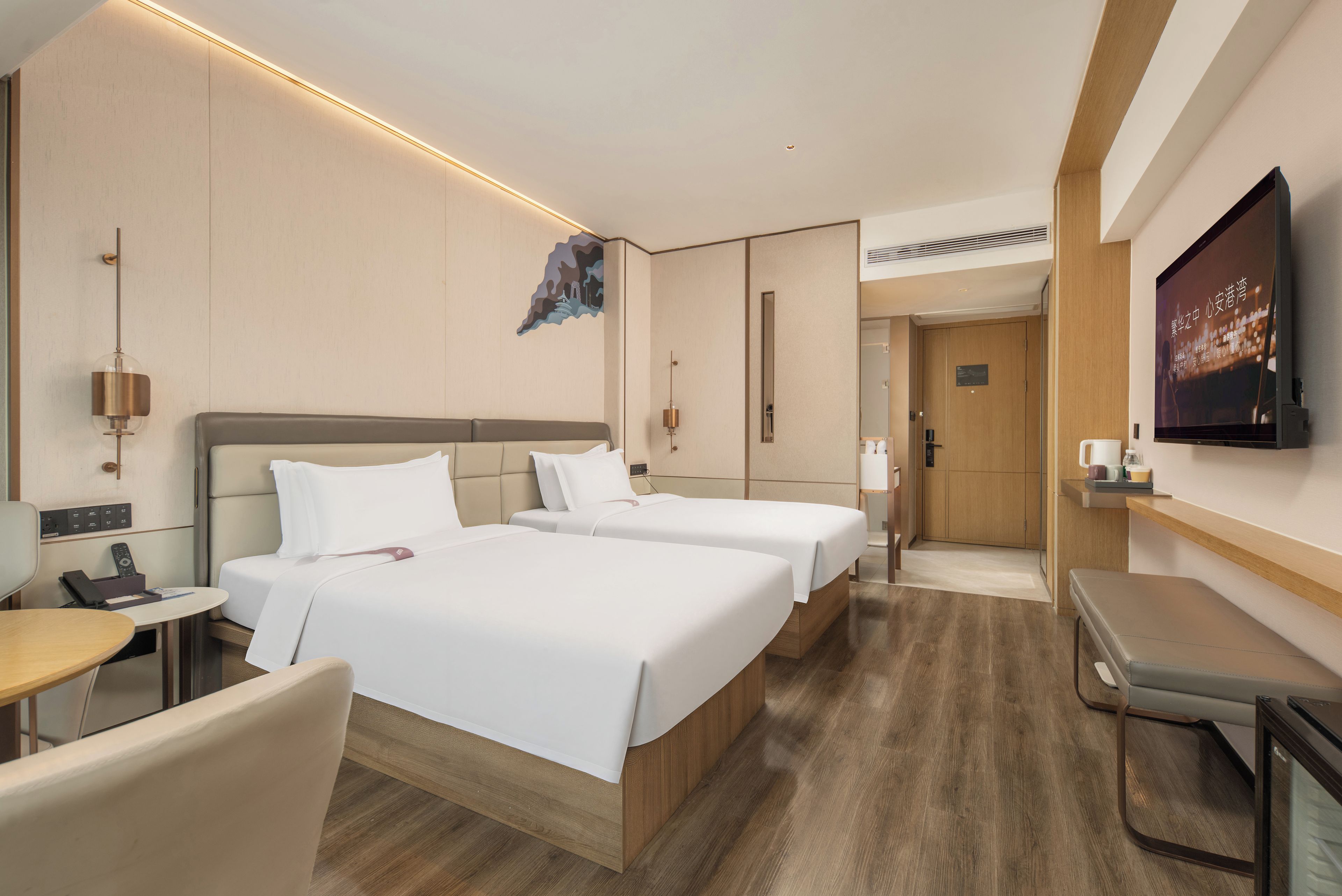 Une chambre d’hôtel avec deux lits, un bureau, une chaise, une télévision et une porte de salle de bain.
