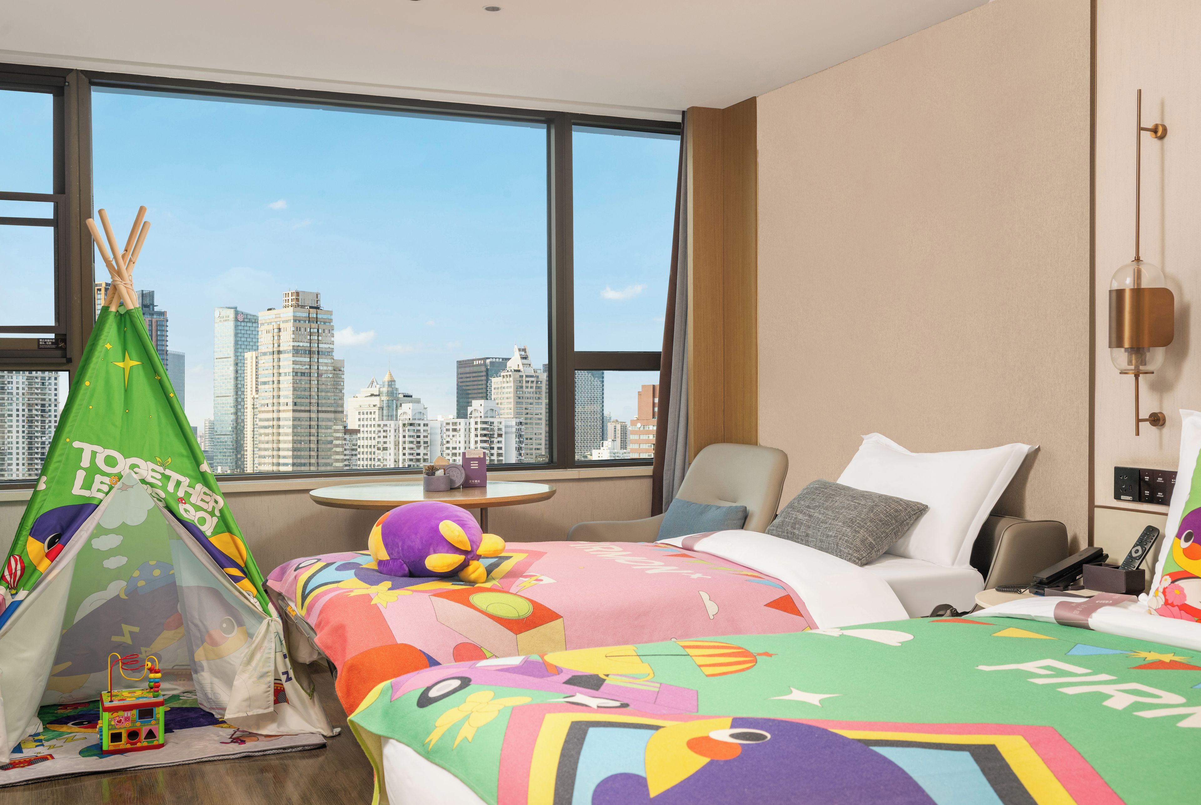 Quarto de hotel com vista para a cidade, uma cama, uma cadeira, uma mesa e uma tenda verde.