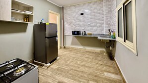 Eine kleine Küche mit Kühlschrank, Herd und Mikrowelle.