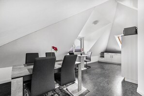 Un comedor moderno y minimalista con techo alto y tejado inclinado.