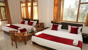 A hotel room with two beds, a wooden chair, a small table with a bottle and a glass, and large windows with curtains. - Asha Residency By St Hotel (Shimla)