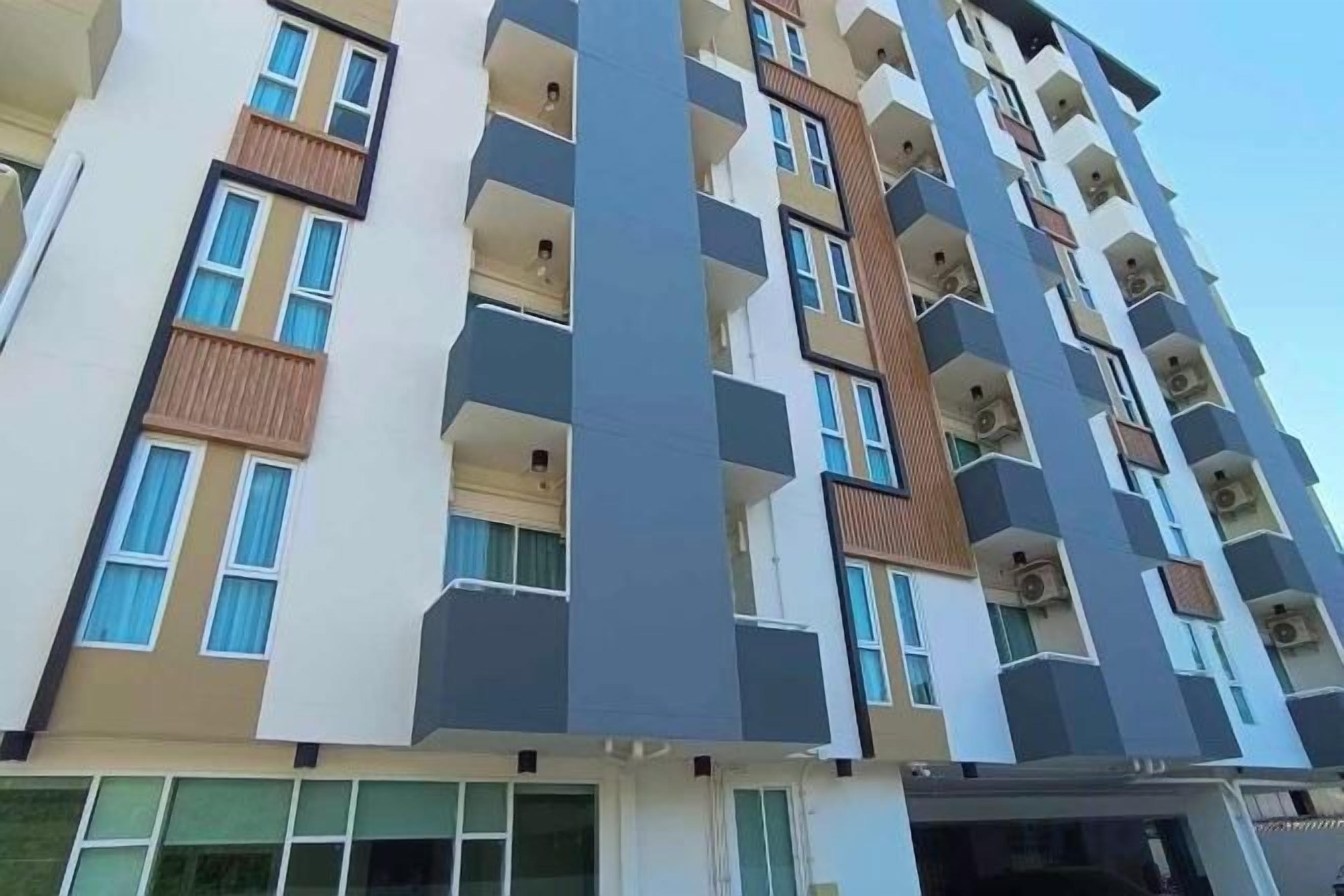A multi-story residential building with balconies, large windows, and a modern architectural design.