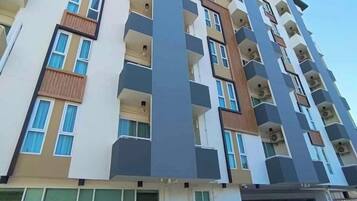A multi-story residential building with balconies, large windows, and a modern architectural design.